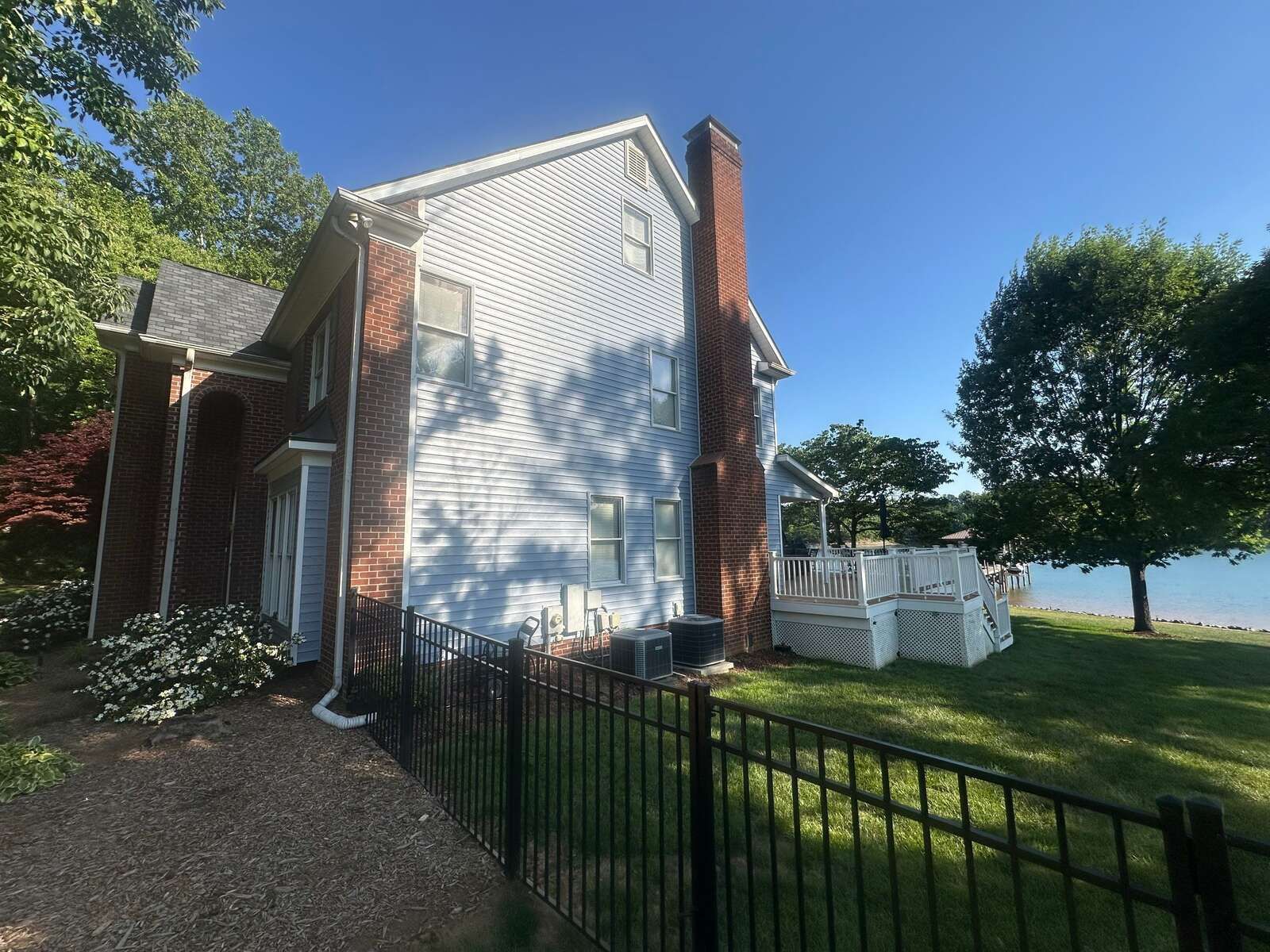 Side elevation with brick chimney and Lake Norman visible behind a Mooresville home